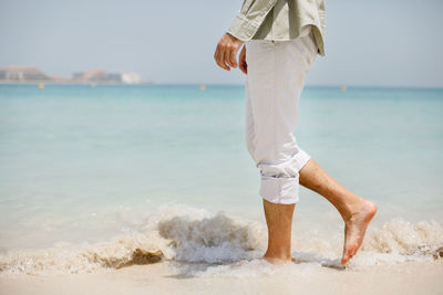 A man walks on the background of a beautiful white sand beach