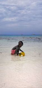Full length of boy on beach against sky