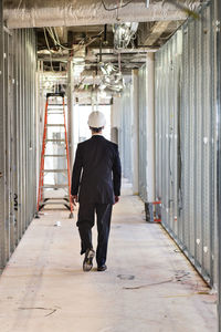 Rear view of engineer walking in corridor