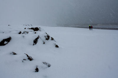 Man walking on snow covered landscape