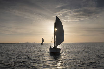 Sailboat on sea against sky during sunset