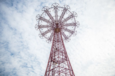 Low angle view of ferris wheel against cloudy sky