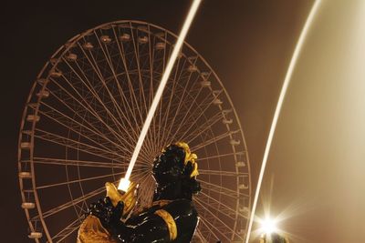 Low angle view of illuminated ferris wheel against sky at night