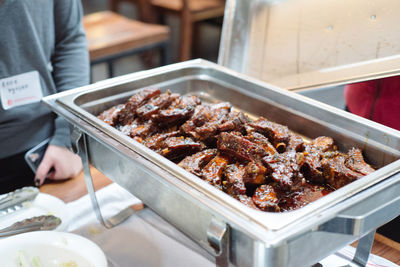 Close-up of man preparing food on barbecue grill