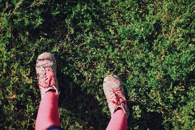 Low section of girl standing on grassy field