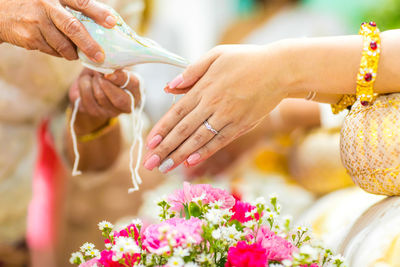 Close-up of hand holding bouquet of red flowering plant