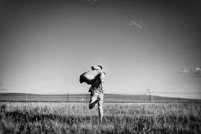 Rear view of man running on grass field