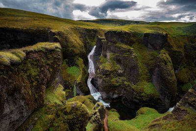 Scenic view of waterfall against sky