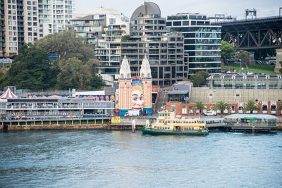 Boats in river against buildings in city