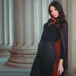 Young woman standing against wall