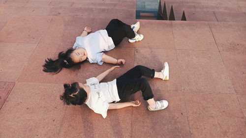 High angle view of friends sleeping on tiled floor