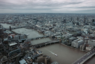 High angle view of illuminated city by river against sky
