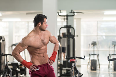 Muscular shirtless man standing in gym