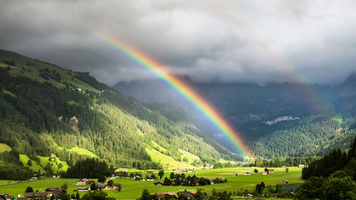 Scenic view of rainbow over mountains against sky