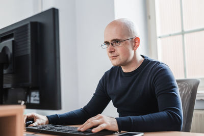 Portrait of young man using laptop at home