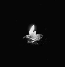 Close-up of lit candle in darkroom