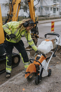 Female road worker operating machinery