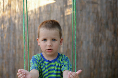 Close-up of boy on swing