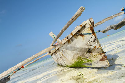 Traditional windmill on beach against sky