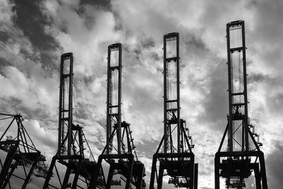 Low angle view of cranes against sky