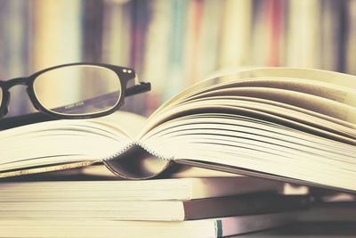 Close-up of open book with eyeglasses