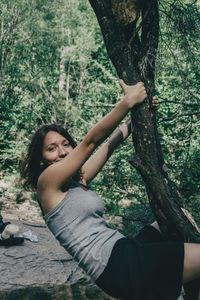 Woman sitting on tree trunk