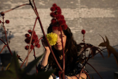 Portrait of woman holding yellow flower