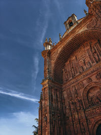 Low angle view of sculptures on building against sky