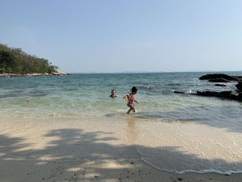 People on beach against sky