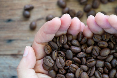 Close-up of hand holding coffee beans