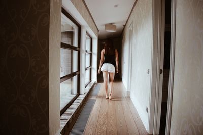 Rear view of young woman walking in corridor