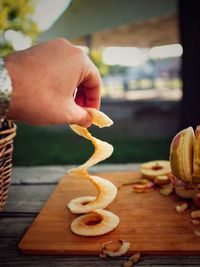 Cropped image of person holding fruits on cutting board