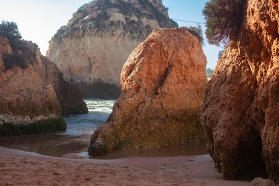 Rock formation on beach against sky