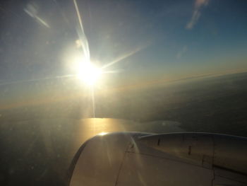 Close-up of airplane wing against sky during sunset