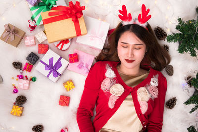 High angle view of young woman sleeping on bed at home during christmas