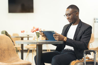 A black businessman works on his laptop in a cafe.