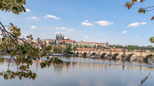 Arch bridge over river against buildings in city