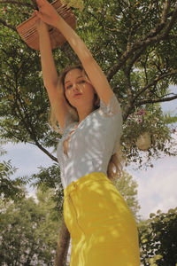 Low angle view of woman standing by plants