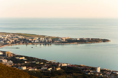 Scenic view of sea by cityscape against sky