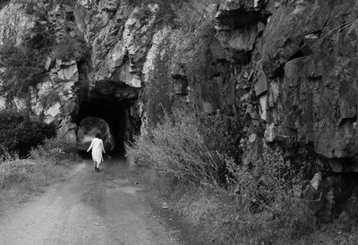 Rear view of people walking on rock