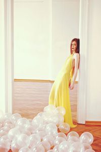 Portrait of woman standing by balloons at doorway