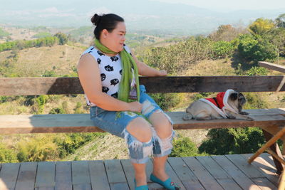 Woman with dog sitting on bench