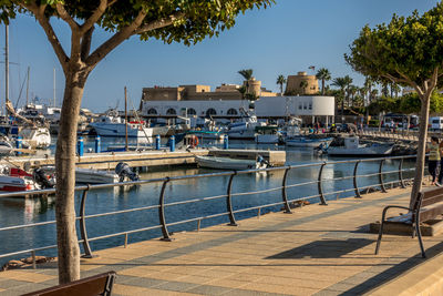 Sailboats moored at harbor by sea against sky