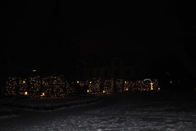 Illuminated city against sky during winter at night