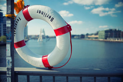 Close-up of life belt on railing against river