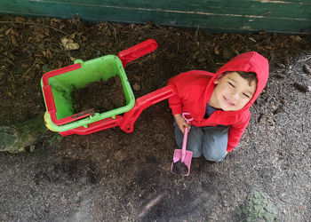 Child plays with wheel barrow and soil