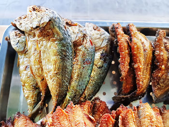 Fried mackerel and salted fish on stainless steel tray