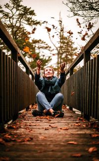 Portrait of man sitting on railing