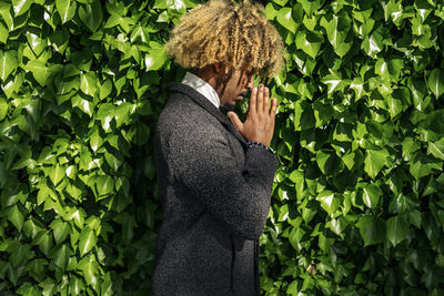 Side view of man standing by plants