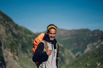 Portrait of young man standing against mountain